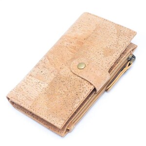 May include: A light brown cork wallet with a zipper closure and a snap closure. The wallet has a textured surface and a gold-colored zipper pull.