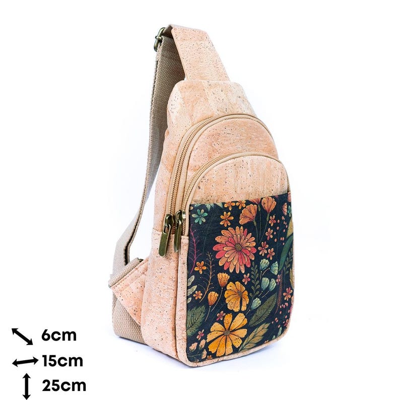 May include: A beige cork sling backpack featuring a front pocket with a dark blue floral print. The bag has a beige adjustable strap and two zippered compartments. Dimensions are 6 cm in depth, 15 cm in width, and 25 cm in height as indicated.
