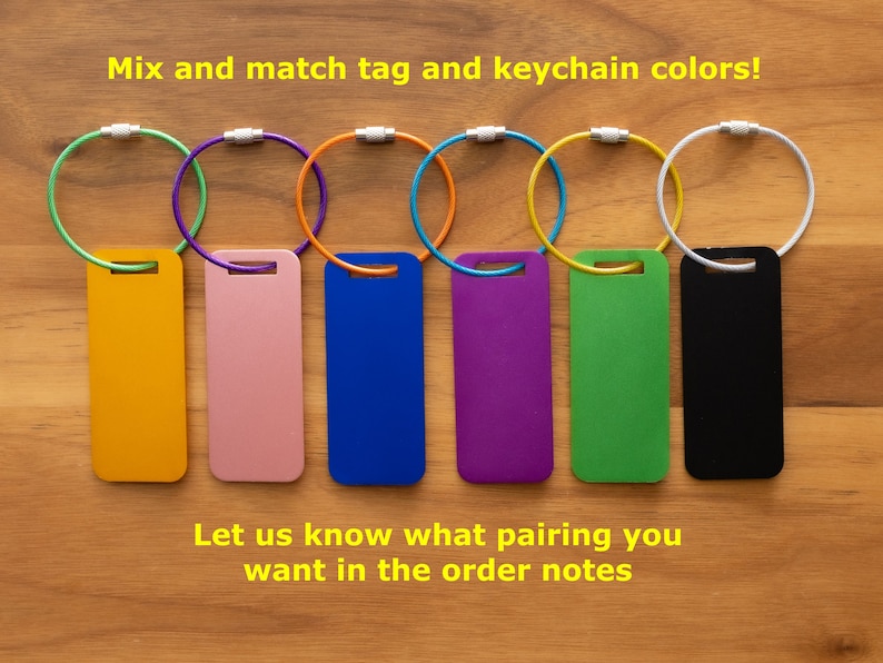 May include: Seven different colored keychains with matching colored tags. The keychains are silver and the tags are yellow, pink, blue, purple, green, and black.