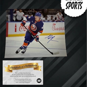 May include: An autographed photo of a hockey player in a blue and orange uniform, with the text "GET IN THE GAME SPORTS" in a white circle. Includes a certificate of authenticity.