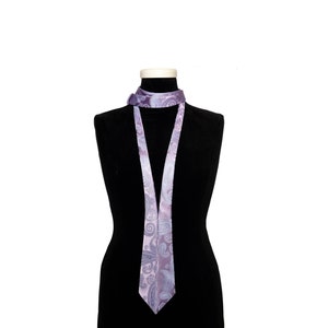 May include: A purple and gray patterned tie on a black mannequin.
