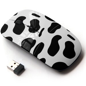Könnte beinhalten: Eine weiße drahtlose Computermaus mit einem schwarzen Kuhmuster. Die Maus wird mit einem USB-Empfänger geliefert.