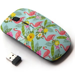 Puede incluir: Un ratón inalámbrico para ordenador con un diseño tropical con flamencos rosas, hojas verdes y flores de colores sobre un fondo azul claro.