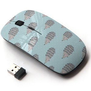 Könnte beinhalten: Eine drahtlose Computermaus mit einem hellblauen Design, das ein sich wiederholendes Muster von schlafenden Igeln zeigt. Die Maus hat ein schwarzes Scrollrad und einen schwarzen USB-Empfänger.
