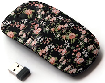 May include: A black wireless mouse with a floral pattern featuring pink and white flowers on a black background. The mouse has a USB receiver.