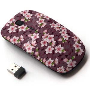 May include: A wireless computer mouse with a pink and white floral design. The mouse is a dark grey colour and has a USB receiver.