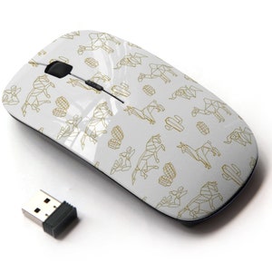 Puede incluir: Un ratón inalámbrico para ordenador blanco con un patrón geométrico dorado de cactus y llamas. El ratón tiene una rueda de desplazamiento negra y dos botones.