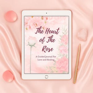 May include: A digital tablet shows the cover of a guided journal titled "The Heart of The Rose." The cover features pink roses and the subtitle "A Guided Journal For Love and Healing." A gold pen and rose quartz crystal are next to the tablet.
