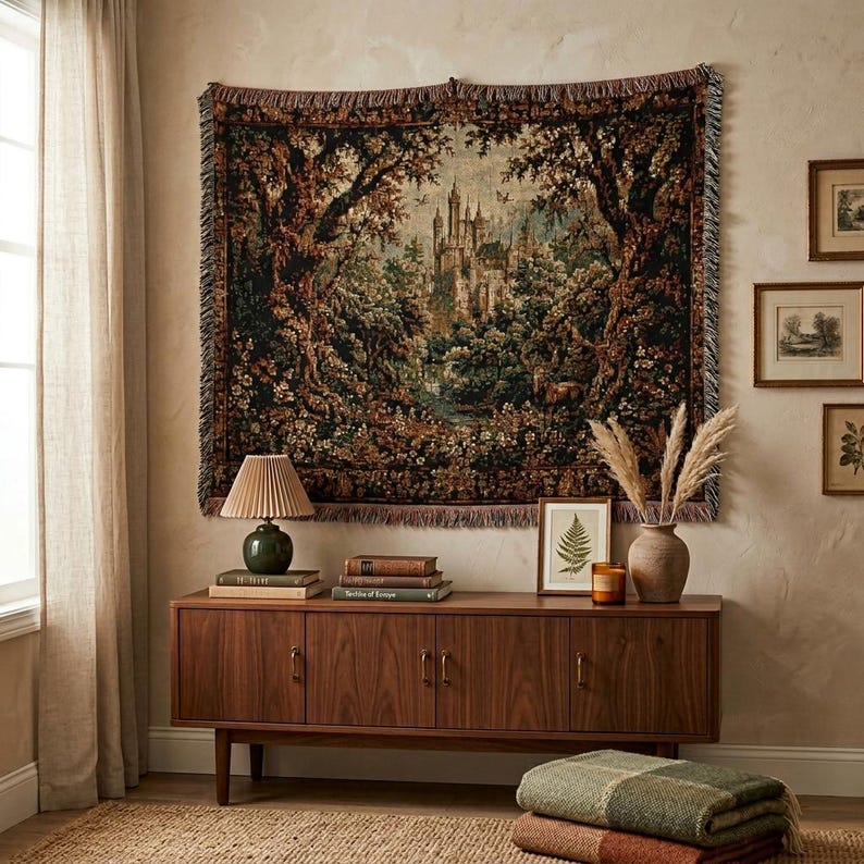 Puede incluir: Un tapiz de pared tejido rectangular que presenta una escena de paisaje detallada con un castillo central rodeado de &aacute;rboles densos, follaje y flores en tonos verde oscuro, marr&oacute;n y dorado, acabado con un borde con flecos en los cuatro lados.