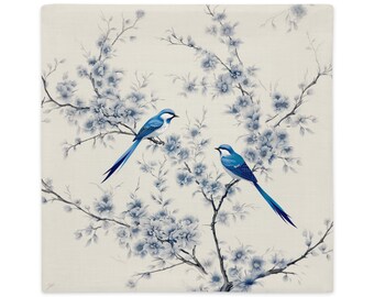 以下が含まれることがあります： 白い花が咲いた木の枝に、青い鳥が2羽とまっている。鳥たちは向き合っており、長く細い尾を持っている。背景は薄いベージュ色である。