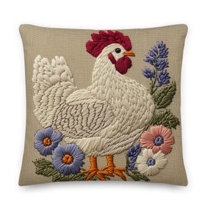 May include: Embroidered decorative pillow featuring a white rooster with a red comb and wattle, surrounded by blue, pink, and white flowers. The pillow has a tan background and is a square shape.