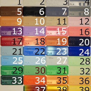 May include: A grid of 39 small plastic squares, each with a different colour and a number from 1 to 39. The squares are arranged in six rows and seven columns. The squares are all the same size and shape. The colours of the squares are a variety of bright colours, including red, orange, yellow, green, blue, purple, and brown.