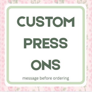 Könnte beinhalten: Ein quadratisches Schild mit weißem Hintergrund und hellgrünem Rand. Der Text CUSTOM PRESS ONS ist in großen, dunkelgrünen Großbuchstaben gedruckt. Darunter steht der Text message before ordering in kleineren, dunkelgrünen Buchstaben.
