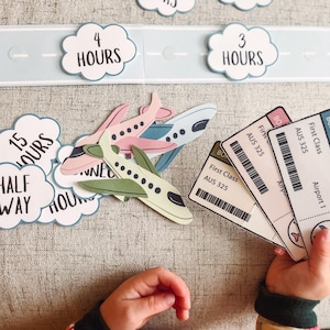 Puede incluir: Un conjunto de recortes de aviones de papel de colores y tarjetas en forma de nube con texto que dice "4 horas", "3 horas", "2 horas", "15 horas", "A mitad de camino", y "Tarjeta de embarque - Primera clase - AUS 325 - Aeropuerto 1".