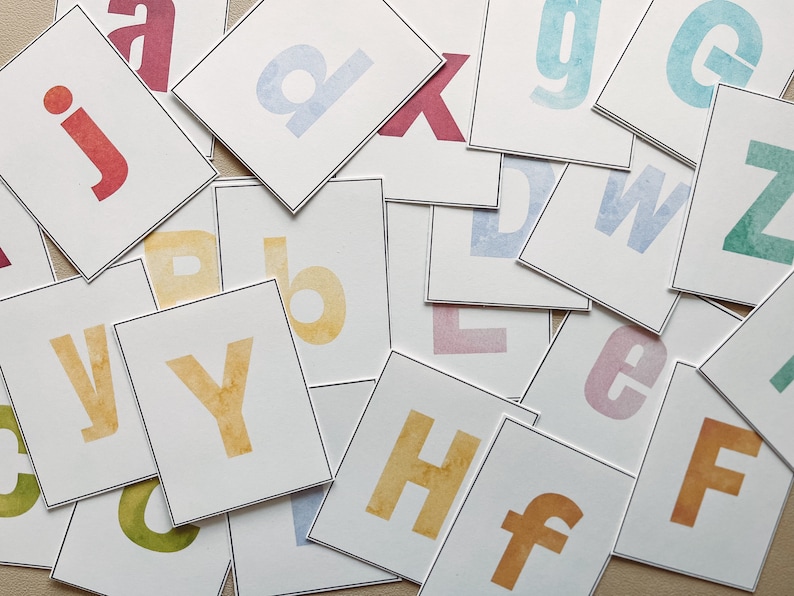 May include: A set of alphabet flashcards with watercolor painted letters on white cardstock. The letters are in various colors, including blue, green, yellow, red, and pink.