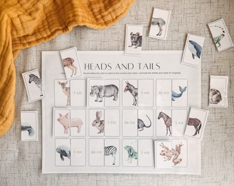 May include: A printable educational game for kids featuring a white sheet with the words "Heads and Tails" and a grid of 16 squares. Each square has a different animal head or tail, with the words "Head" or "Tail" written below. The game includes 16 cards with animal illustrations, each card showing either the head or tail of the animal.