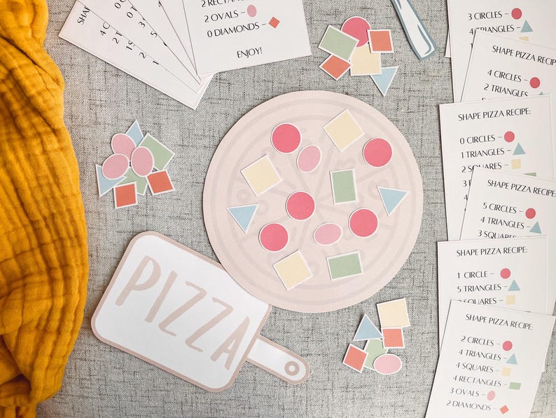 Pu&ograve; includere: Un tabellone di gioco a forma di pizza con una variet&agrave; di forme colorate, tra cui cerchi, quadrati, triangoli e rettangoli. Il tabellone di gioco &egrave; circondato da carte con diverse ricette di pizza a forma.