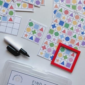 May include: A children's activity kit with colorful pattern cards, a red frame, and a dry-erase marker. The cards feature various shapes and colors. The kit includes a pattern finder and 18 pattern cards. The text "Find the Pattern" is visible.