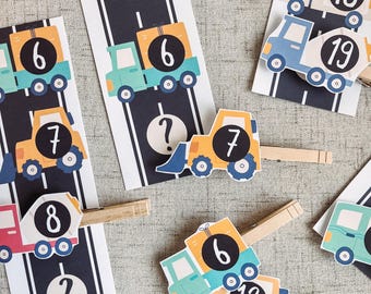 Puede incluir: Un juego de tarjetas de conteo de vehículos de construcción coloridos con pinzas para la ropa a juego. Las tarjetas muestran los números 6, 7, 8, 12, 17, 18 y 19. Algunas tarjetas tienen signos de interrogación en lugar del número.