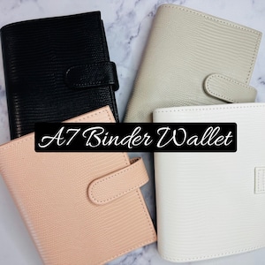 May include: Four A7 binder wallets in different colors: black, beige, light pink, and white. The wallets have a textured, snakeskin-like pattern and a flap closure with a button.