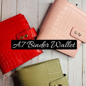 May include: Three A7 binder wallets in different colors: red, pink, and green. Each wallet has a crocodile embossed texture and gold metal accents.