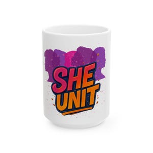 May include: White ceramic mug featuring the text "SHE UNIT" in a vibrant design. The text is in orange and pink with a blue outline. Silhouettes of women in purple and pink are behind the text.