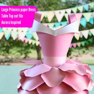 Pode incluir: Um grande vestido de princesa de papel rosa com uma gola branca. O vestido é um arquivo de corte de mesa e é inspirado em Aurora.