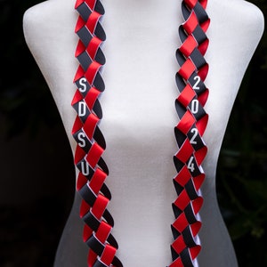 May include: A red and black graduation lei with the letters "SDSU" and the numbers "2024" printed on it.