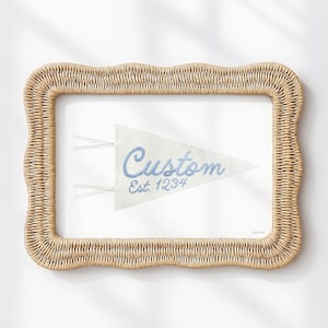 May include: A framed pennant with the word "Custom" in blue script and the year "Est. 1234". The pennant is white and framed in a woven, light brown material.
