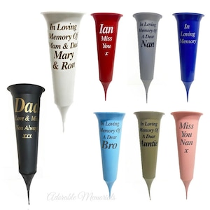 May include: Assortment of ten plastic flower vases with different coloured bases and personalised messages. The vases are all the same shape and size. The messages include "Dad", "Ian", "Miss You", "In Loving Memory Of A Dear Nan", "In Loving Memory Of Mam & Dad Mary & Ron", "In Loving Memory Of A Dear Bro", "In Loving Memory Of A Dear Auntie", "In Loving Memory", and "Miss You Nan".