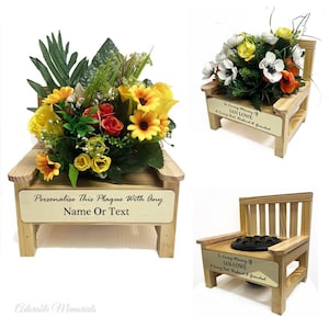 May include: Three wooden memorial benches, each with a different floral arrangement. One bench has a plaque with the text "Personalise This Plaque With Any Name Or Text." The other two have plaques that read "In Loving Memory of IAN LOWE & Loving Dad, Husband & Grandad."