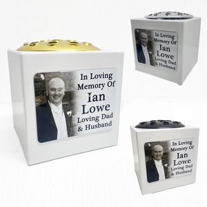 Può includere: Vaso di fiori in ceramica bianca con una foto in bianco e nero di un uomo e il testo "In Loving Memory Of Ian Lowe Loving Dad & Husband".