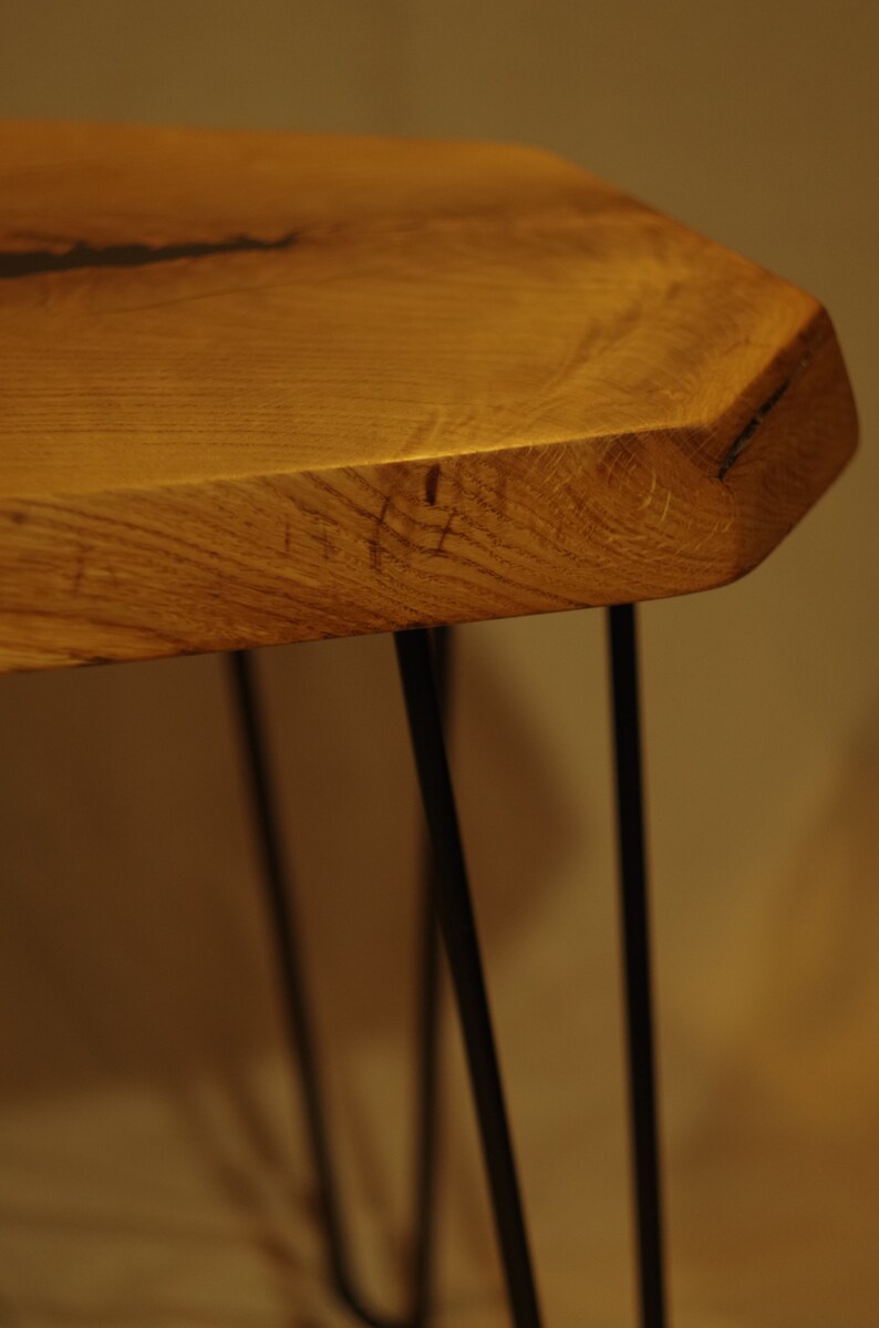 Op de afbeelding: Een houten tafel met een live edge blad en zwarte haarspeldpoten. De tafel is gemaakt van natuurlijk hout en heeft een rustieke uitstraling.