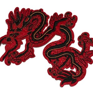 May include: A red and black embroidered dragon patch. The dragon is depicted in a stylized, flowing design with intricate details. The patch features a red background with black and gold accents.