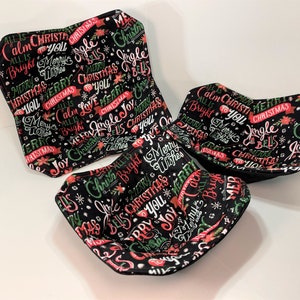 May include: Three black fabric bowls with a Christmas-themed print. The print features red and green lettering on a black background. The lettering includes phrases like "Jingle Bells", "Merry Christmas", and "All is Calm".