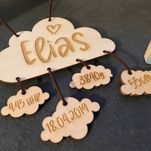 Könnte beinhalten: Hölzerner Wolken-Mobile mit dem Namen "Elias" und Details zur Geburt des Babys: 4:45 Uhr, 18.04.2019, 3840g und 55cm.