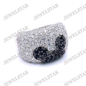 May include: A silver ring with a black and white design. The ring is covered in small, sparkling stones.