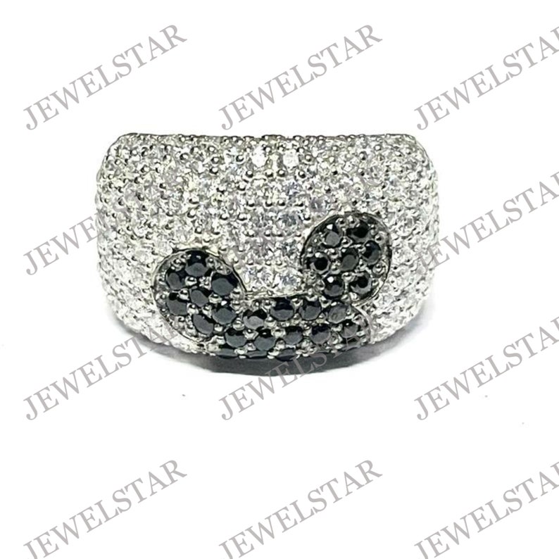 May include: A silver ring with a black and white design. The ring is set with small black and white stones.
