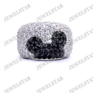 May include: A silver ring with a black and white Mickey Mouse design. The ring is set with small black and white stones.