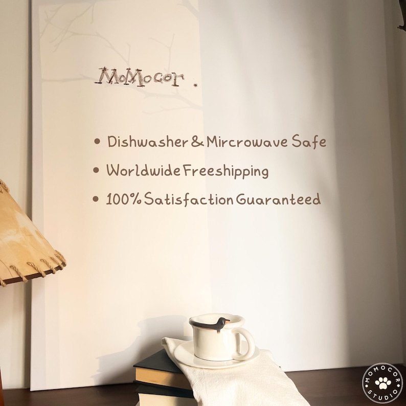 May include: A white ceramic mug with a dachshund dog design, resting on a saucer and a white cloth. The image also shows the text "MoMocor" and the words "Dishwasher & Microwave Safe".