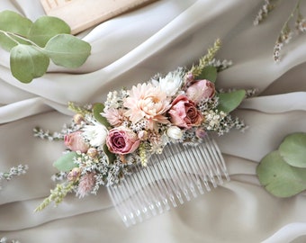 May include: A delicate hair comb adorned with dried flowers in shades of pink and white. The comb features a cluster of roses, baby's breath, and eucalyptus leaves.