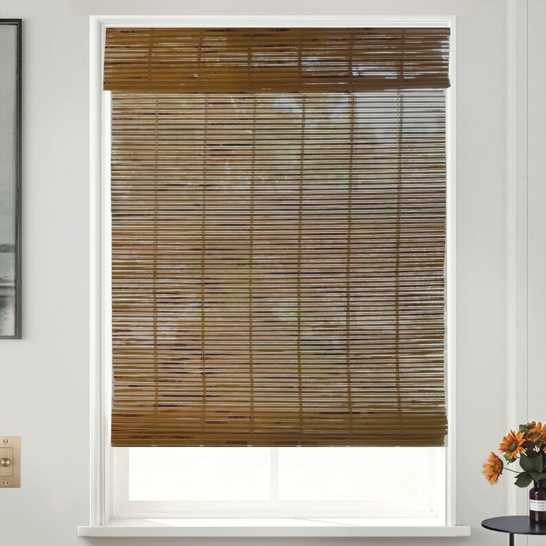 May include: Brown bamboo window blinds with a white frame. The blinds are fully extended, showing the natural texture of the bamboo.