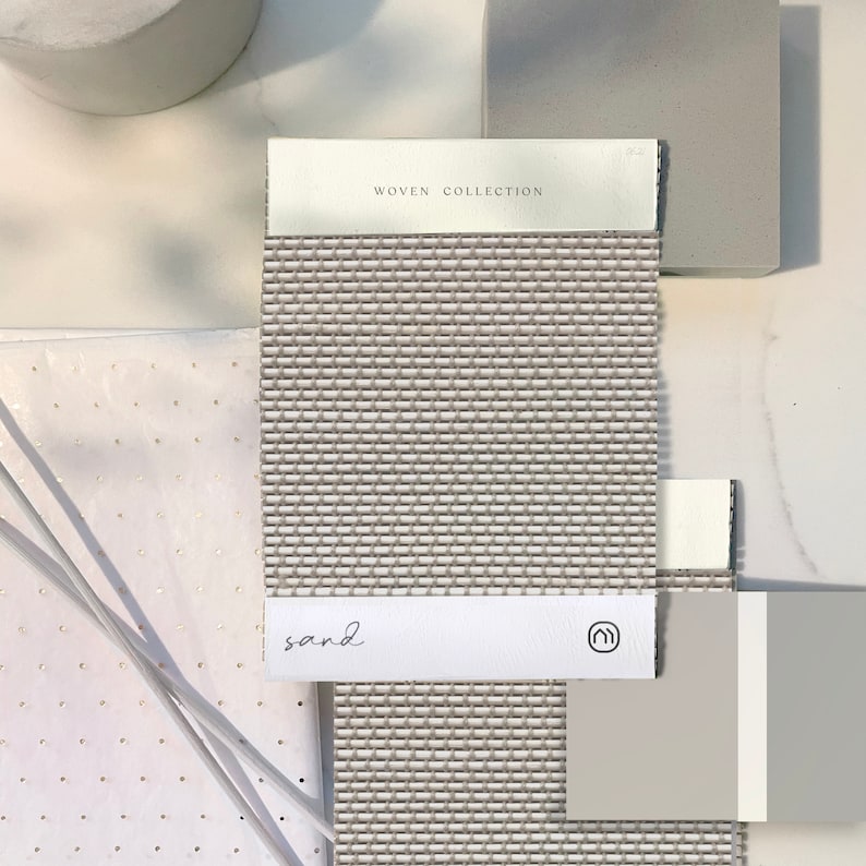 K&ouml;nnte beinhalten: Ein gewebtes Stoffmuster in hellbrauner Farbe mit dem Text "WOVEN COLLECTION" und "sand" darauf gedruckt. Das Muster wird mit einem wei&szlig;en und einem grauen Musterkarten gezeigt.