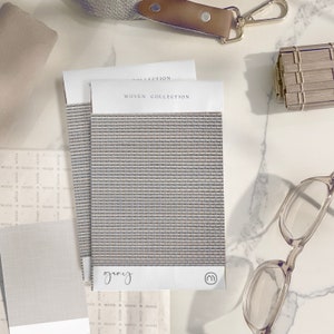 K&ouml;nnte beinhalten: Ein Nahaufnahme eines gewebten Stoffmusters mit der Aufschrift "gray" und dem Text "WOVEN COLLECTION" dar&uuml;ber. Der Stoff hat eine dezente, hellgraue Farbe und eine gewebte Textur.