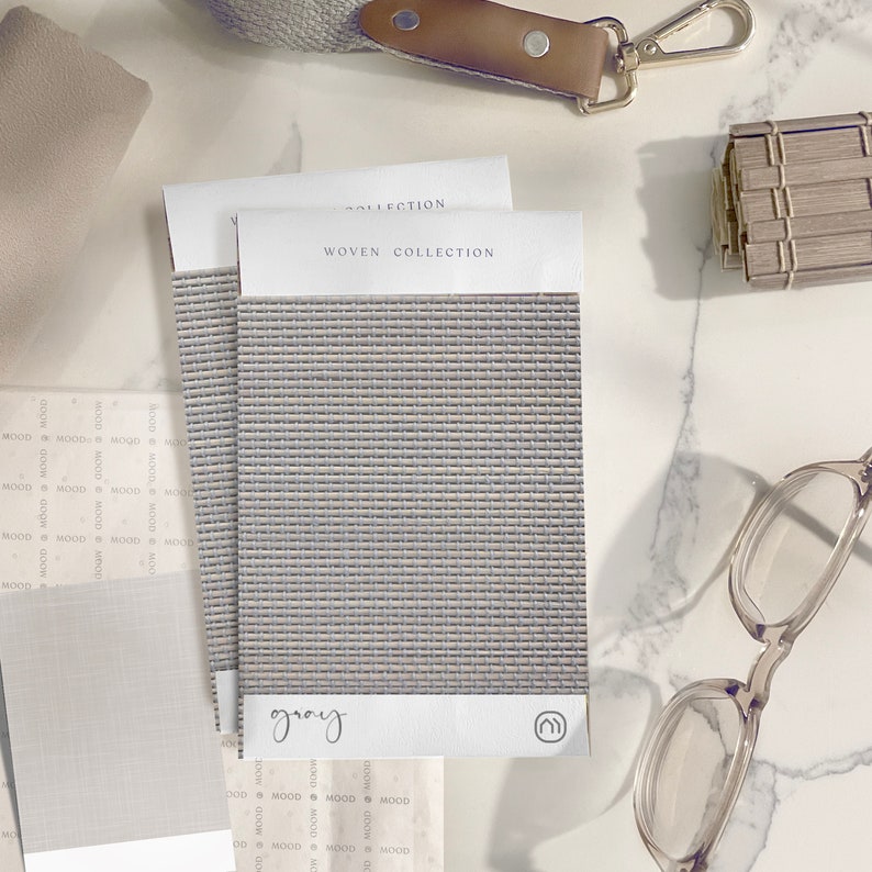 K&ouml;nnte beinhalten: Ein Nahaufnahme eines gewebten Stoffmusters mit der Aufschrift "gray" und dem Text "WOVEN COLLECTION" dar&uuml;ber. Der Stoff hat eine dezente, hellgraue Farbe und eine gewebte Textur.