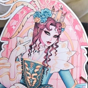 Puede incluir: Una pegatina con una ilustraci&oacute;n estilizada de una mujer con un cors&eacute; turquesa y dorado, adornada con una corona floral y un collar de perlas. La obra de arte tiene un dise&ntilde;o de vidriera rosa y dorada en el fondo, con detalles de plumas.