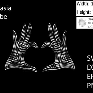 May include: A white rhinestone design of two hands forming a heart shape. The design is 11.594 inches wide and 7.083 inches tall. The design is made with 1293 clear crystals.
