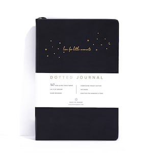 K&ouml;nnte beinhalten: Schwarzes gepunktetes Notizbuch mit goldenen Sternen und dem Schriftzug "live for little moments". Das Notizbuch hat 160 g/m&sup2; ultra-dickes Papier, ein flaches Design und ist handgebunden. Es hat einen Einband aus veganem Leder und ist f&uuml;r Marker und Stifte geeignet.