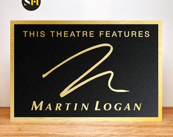 May include: A gold plaque with a black background and gold lettering. The plaque reads "This theatre features Martin Logan".