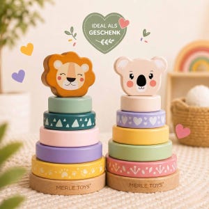 Può includere: Due giocattoli impilabili in legno. Uno presenta una testa di leone, l'altro un koala. Ogni giocattolo ha anelli colorati nelle tonalità di verde, rosa, viola e giallo. Le basi sono in legno con la scritta "MERLE TOYS".